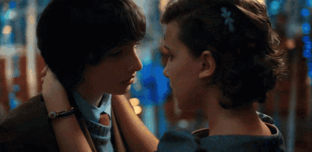 mike and eleven are looking at each other and kissing