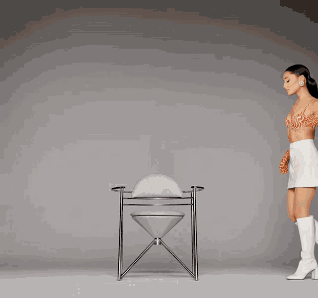 a woman in a white skirt is standing next to an hourglass