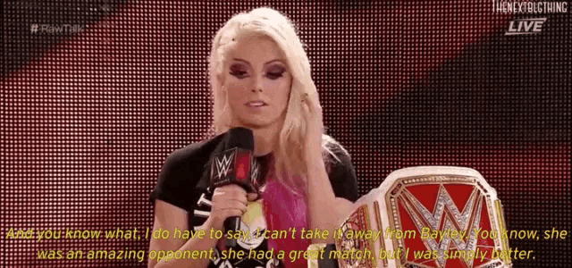 a woman is holding a wrestling championship belt while talking into a microphone .