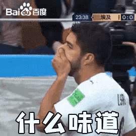 a man with a beard is covering his nose during a soccer match