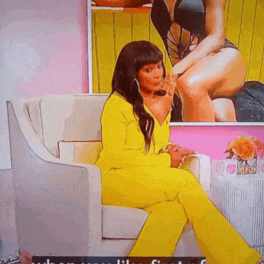 a woman in a yellow suit sits on a chair