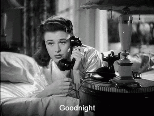 a woman is laying in bed talking on a telephone and the words goodnight are below her