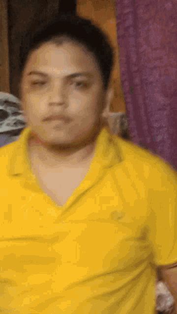 a man wearing a yellow polo shirt is looking at the camera