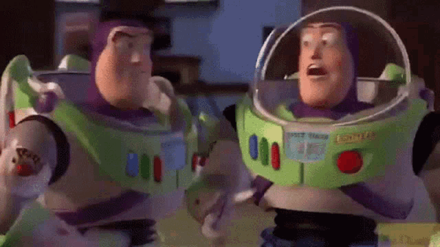two toy story characters buzz lightyear and woody are standing next to each other .