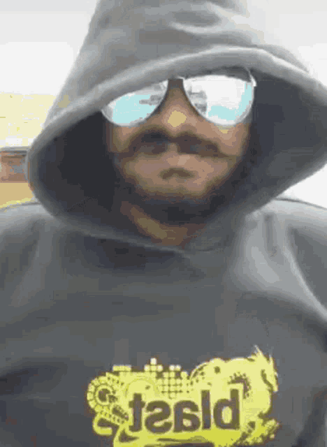 a man wearing sunglasses and a hoodie with the word stasld on his shirt