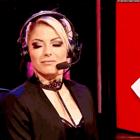 a woman wearing headphones and a microphone is looking at the camera .