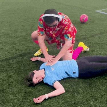 a man is giving a woman a heart attack on a field