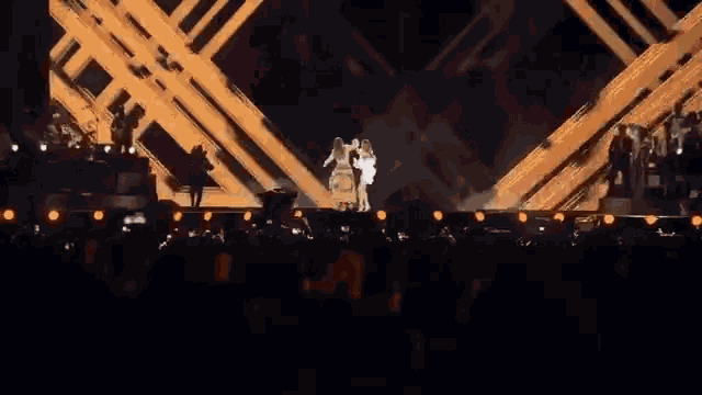two women are dancing on a stage and one is wearing a leopard print dress