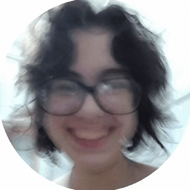 a woman wearing glasses is smiling and looking at the camera