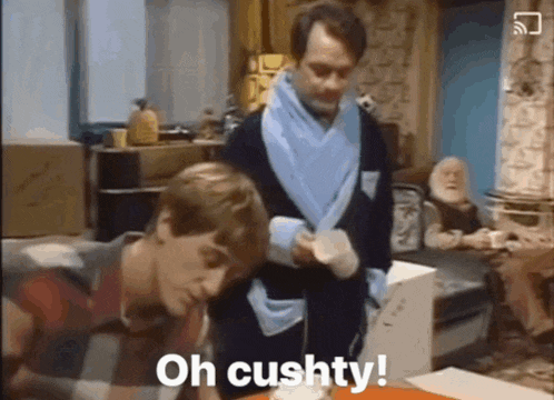 a man in a robe is standing next to another man and says oh cushy
