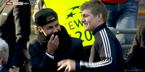 two men laughing in front of a yellow sign that says ew 20