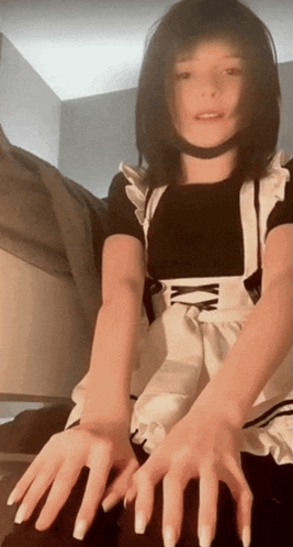 a woman wearing a maid costume with long nails