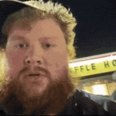 a man with a beard is standing in front of a waffle house