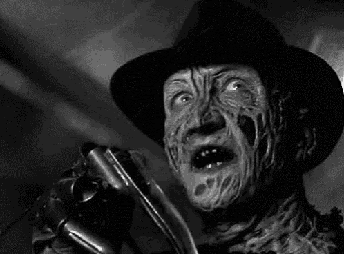 a black and white photo of freddy krueger from a nightmare on elm street holding a knife .