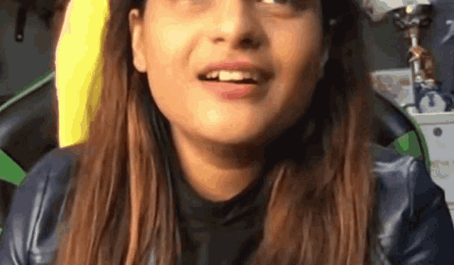 a close up of a woman 's face with a black jacket on