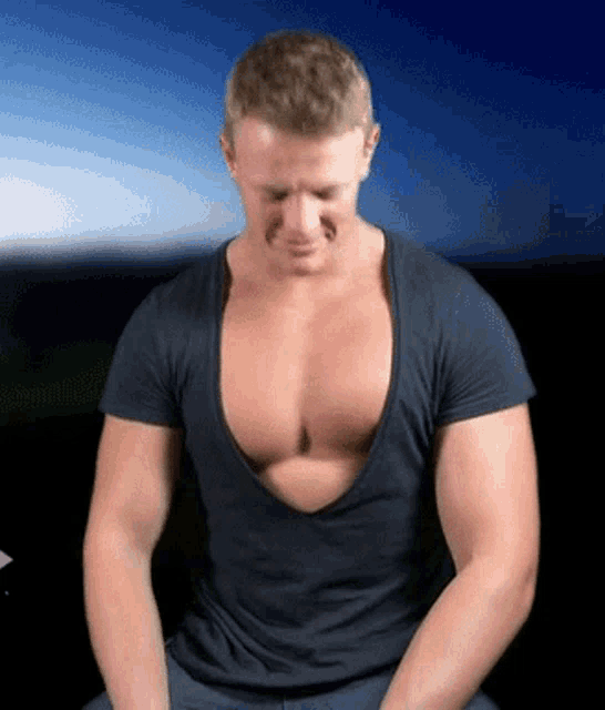 a man in a black shirt with a very deep neckline