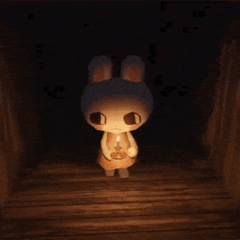 a bunny rabbit is holding a candle in a dark room .