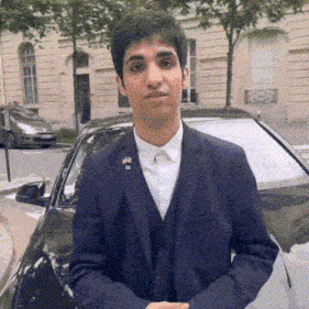 a man in a suit is standing next to a car