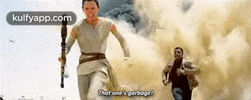 a man and a woman are running in the desert and the woman is holding a sword .