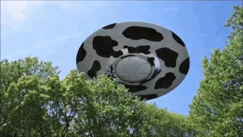 a cow print ufo is flying through the sky