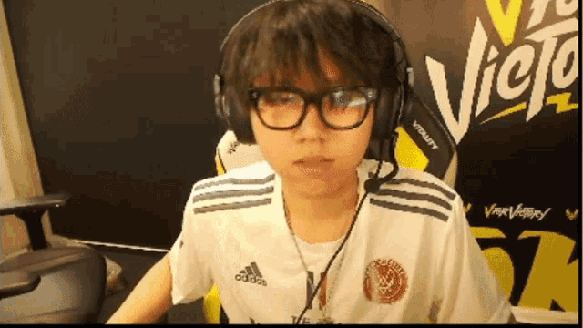 a person wearing glasses and headphones with the word victory behind them