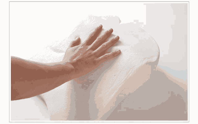 a person 's hand rests on a white foam cushion