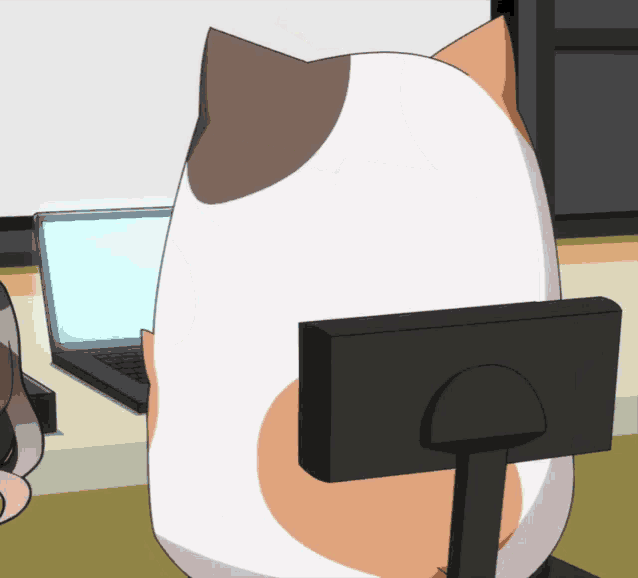 a calico cat is sitting in front of a laptop