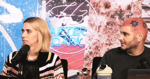 a man and a woman sit in front of a neon sign that says after dark