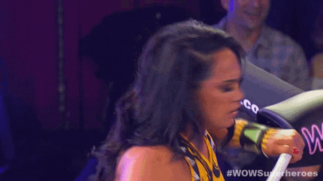 a woman in a wrestling ring with #wowsuperheroes on the bottom right