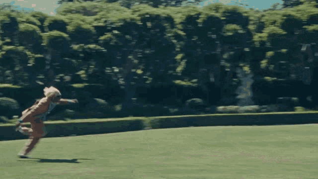 a man in a brown suit is running in a park