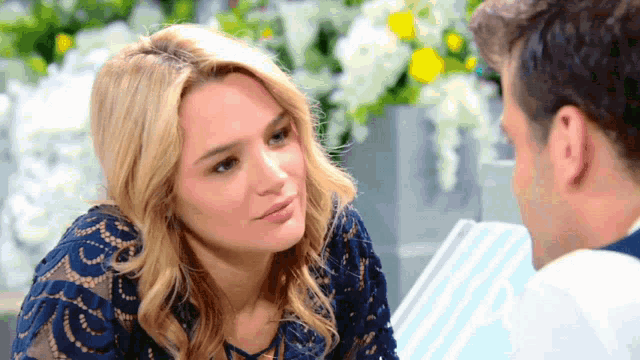 a woman in a blue dress is looking at a man