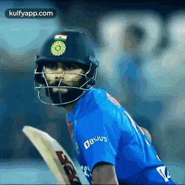 a cricket player wearing a helmet is holding a bat