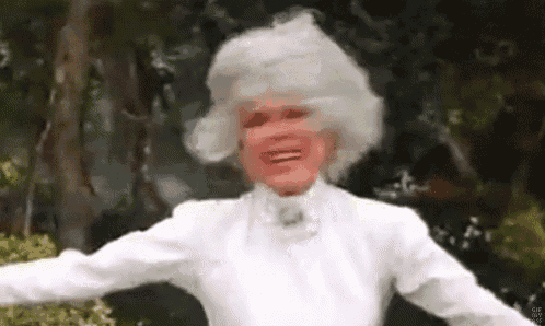 a woman with white hair and a white shirt is dancing in a park .