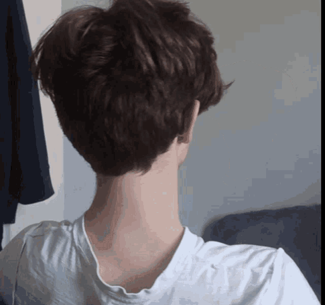 the back of a person 's neck is shown in a white shirt