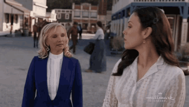two women are standing next to each other in front of a building that says hallmark channel