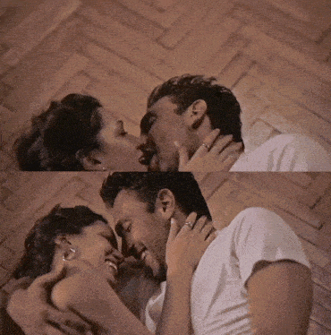 a man and a woman are kissing on a wood floor