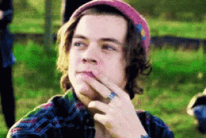 a young man wearing a pink hat and a plaid shirt is thinking