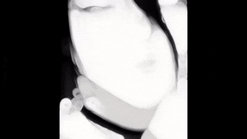 a black and white photo of a woman 's face with smoke coming out of her mouth .