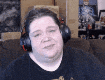 a man wearing headphones is sitting on a couch and making a funny face