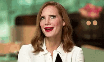 a woman is making a funny face with her mouth open while wearing a white shirt and black tie .