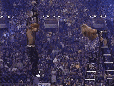 a wrestling match is going on in front of a crowd with a sign that says t.a.w. on it .