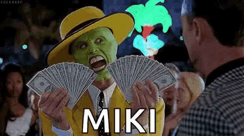 a man in a mask is holding a fan of money and the word miki is on the screen