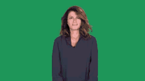 a woman in a blue shirt is making a shocked face on a green screen