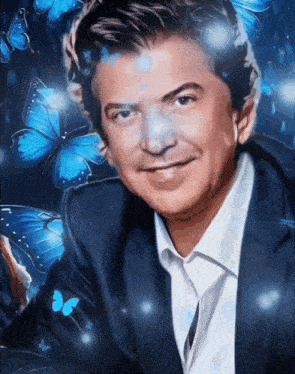 a man in a suit and white shirt is smiling with blue butterflies behind him