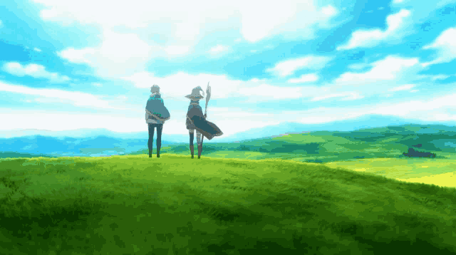 a couple of people standing on top of a hill