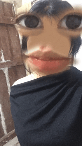 a blurry picture of a woman 's face with a black shirt around her shoulder