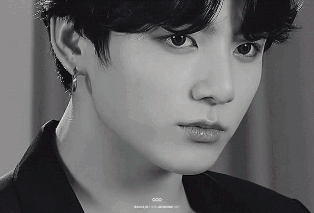 a black and white photo of a young man 's face with a caption that says ' jungkook 1997 '