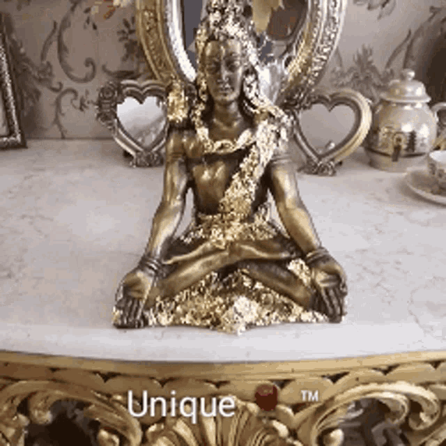 a statue of a woman sitting on a table with the words unique tm on the bottom