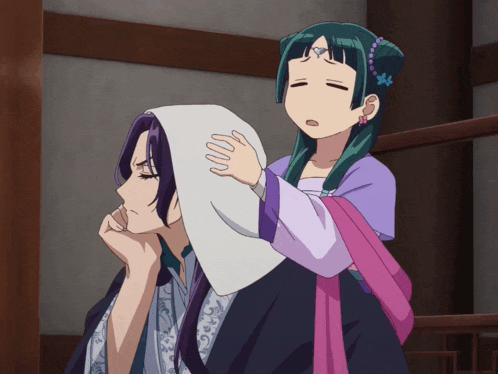 a girl in a pink dress is putting a white cloth on a man 's head