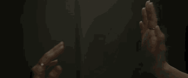 a close up of a person 's hands with rings on their fingers